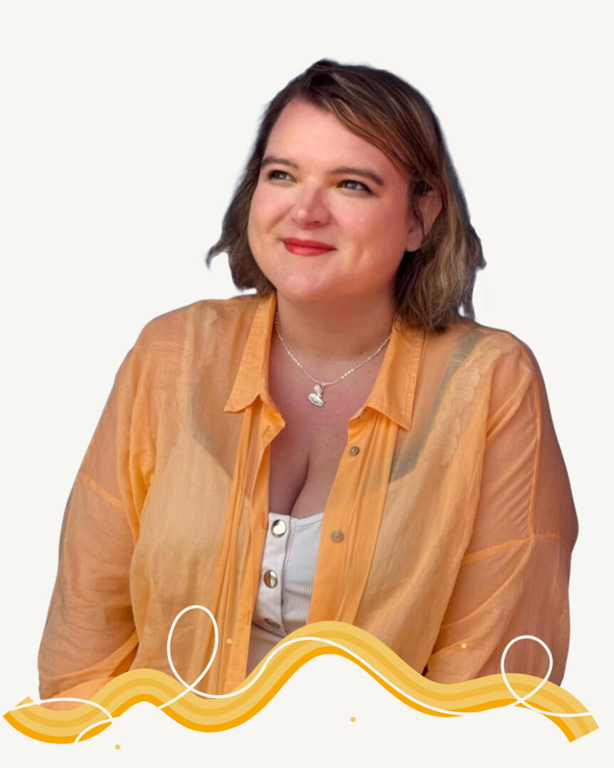 Photo of a white woman with shoulder-length dark blonde hair, smiling while looking up and to the right. Wearing a pale orange shirt over a white tank top and a silver necklace with a charm. Image is cut off at the wasit with a wiggly decorative line in sh